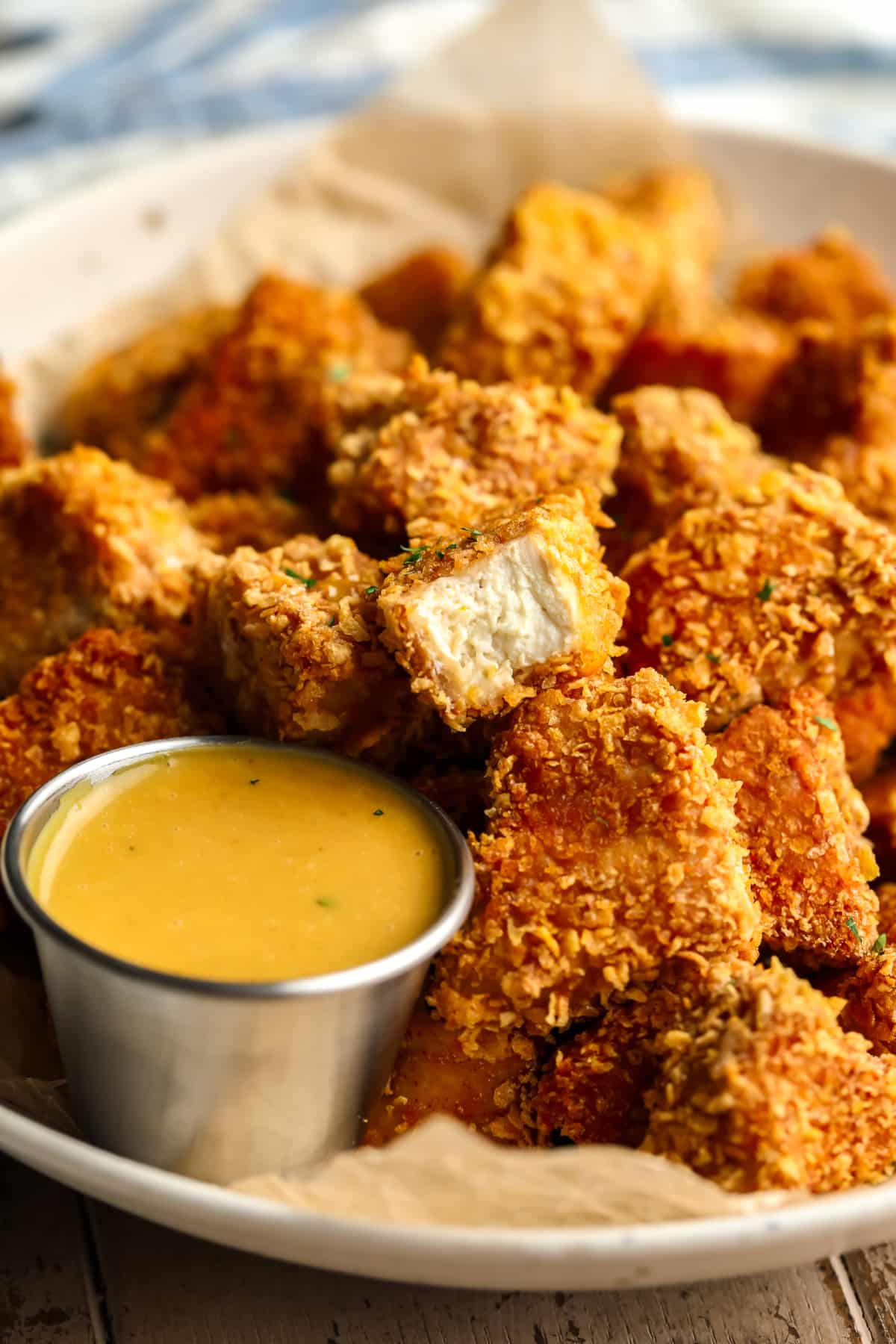 Muitos pepitas de frango veganas em uma tigela com uma mostrando o interior